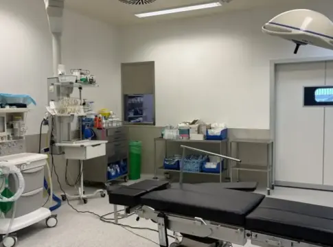 Sala de quirófano con equipos médicos Sala de quirófano vacía con mesa de operaciones y equipos médicos alrededor
