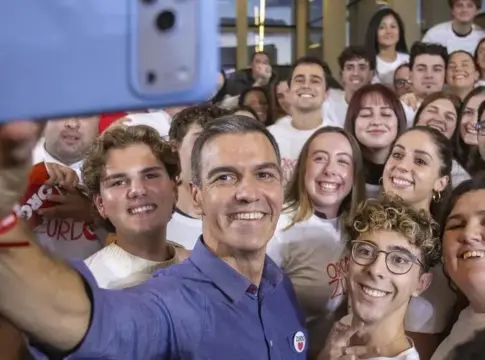 Selfie grupal con jóvenes Un hombre sonríe mientras se toma una selfie con un grupo de jóvenes.