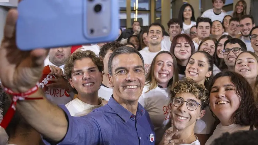 Selfie grupal con jóvenes Un hombre sonríe mientras se toma una selfie con un grupo de jóvenes.