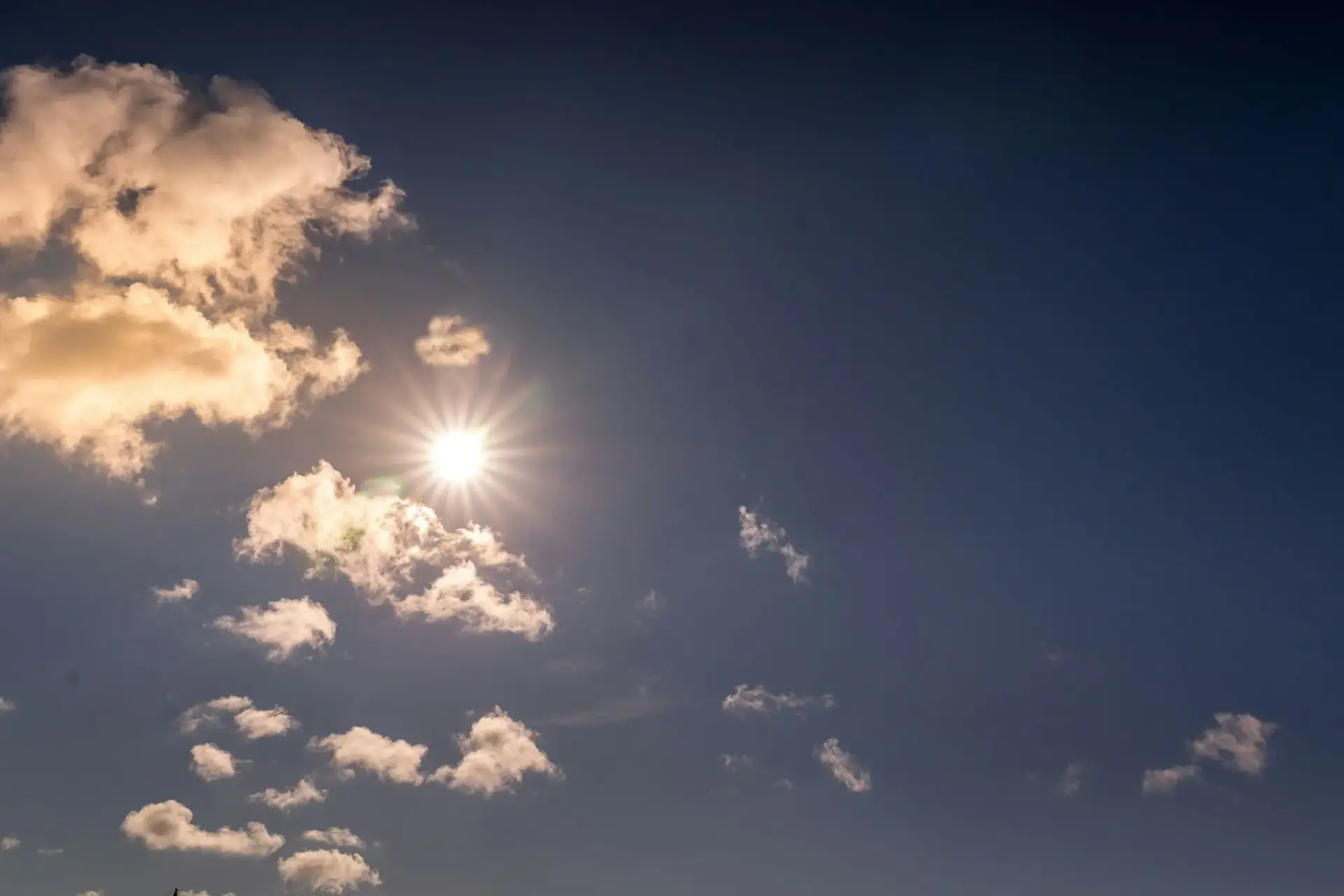 Sol entre nubes en cielo azul septiembre más cálido España