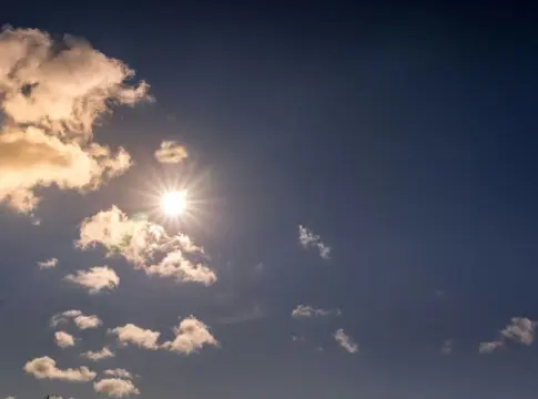 Sol entre nubes en cielo azul septiembre más cálido España