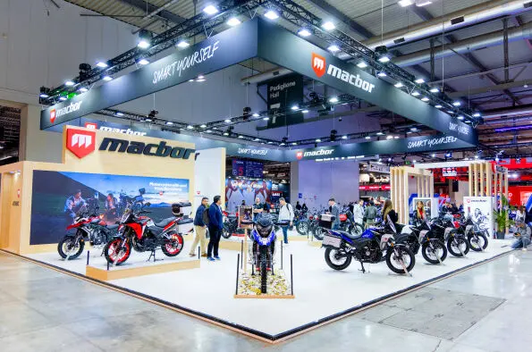 Stand de MACBOR con motocicletas expuestas Stand de MACBOR en una feria de motocicletas, con motos expuestas y visitantes.