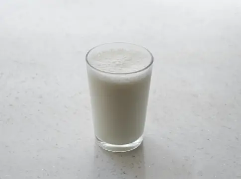 Vaso de leche con espuma dieta alta en proteína