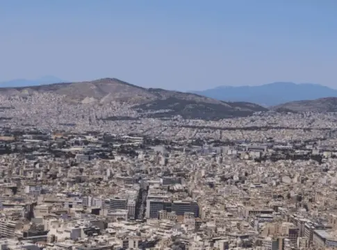 Panorámica urbana con montañas al fondo Vista panorámica de una ciudad extensa con edificios densos y montañas al fondo