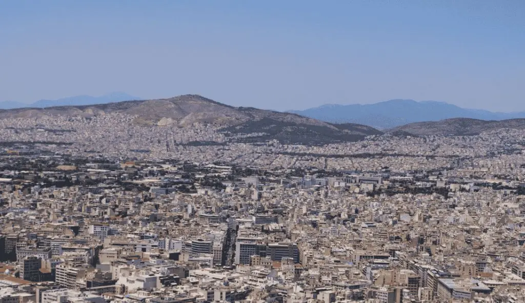 Panorámica urbana con montañas al fondo Vista panorámica de una ciudad extensa con edificios densos y montañas al fondo